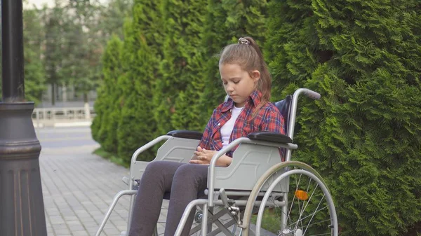 Kız bir özürlü tekerlekli sandalyede hüzünlü olduğunu