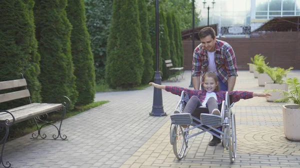 Parkta tekerlekli sandalyede mutlu bir genç adam rulo