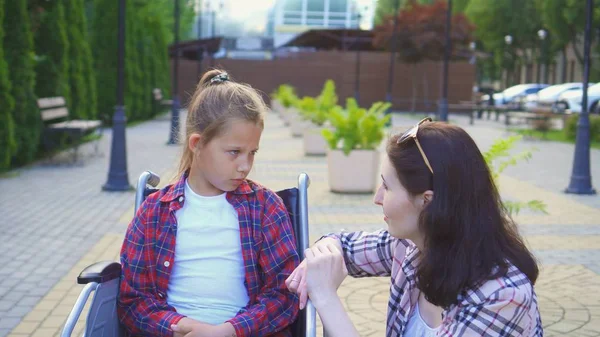 Tekerlekli sandalyede bir Engelli genç sokakta bir gömlek bir kız ile iletişim kurar