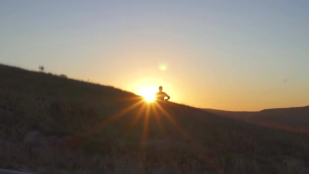 Bir adam kazanan rakam silüeti gün batımına doğru kaçar — Stok video