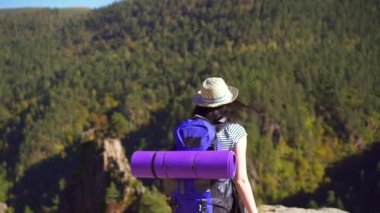 Sırt çantası ile sırtında turist kızla açık silah dağın tepesinde