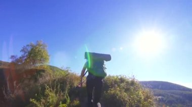 Kadın dağcı dağın tırmanıyor ve ellerini sevinçle yükseltir