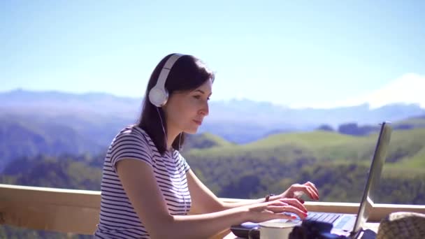 Ragazza blogger digitando sul computer portatile su sfondo di montagne — Video Stock