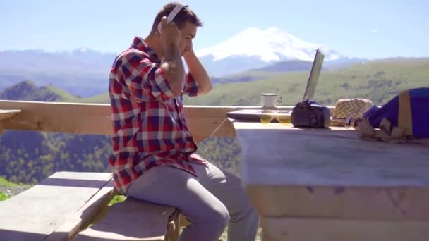 Uomo blogger digitando sul computer portatile su sfondo di montagne — Video Stock