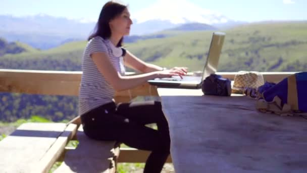 Chica freelancer con portátil regocijo éxito, con montañas en el fondo — Vídeos de Stock