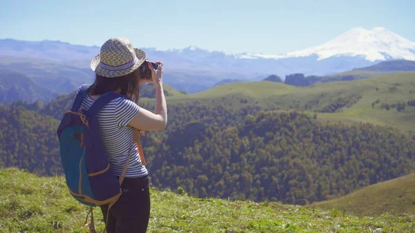 Touristin mit Hut fotografiert schöne Berge — Stockfoto