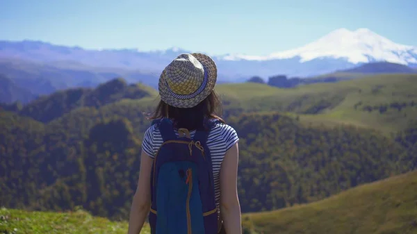 Touristin mit Rucksackmütze vor dem Hintergrund der wunderschönen Berge — Stockfoto