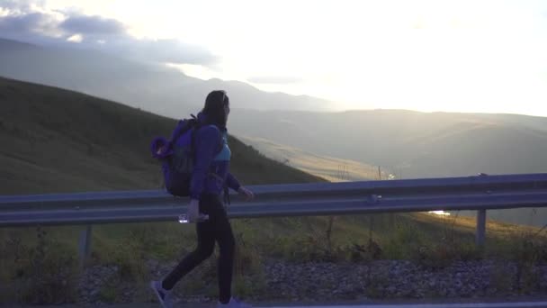 Turystyczna dziewczynka z plecakiem jest na drodze — Wideo stockowe