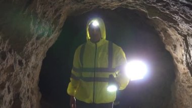 Elinde bir fenerle portre adam gönüllü kurtarıcı bir mağarada, yavaş mo bir adam arıyor