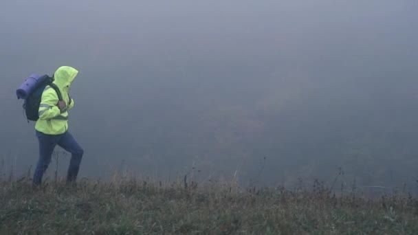 Человек Турист Сигнальном Жилете Капюшоне Рюкзаком Позади Один Тумане Горах — стоковое видео