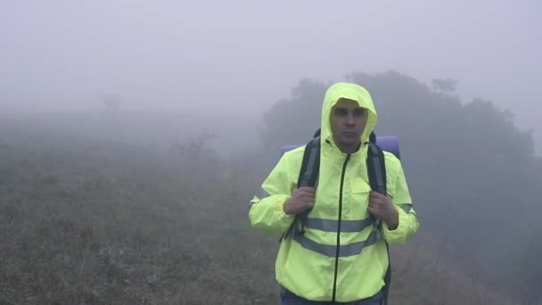 Портрет туриста с рюкзаком ходить в одиночестве в тумане, медленно мо — стоковое видео