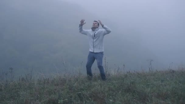 Разочарованный депрессивный человек в депрессии кричит от злости, стоя в одиночестве в тумане, медленное время — стоковое видео
