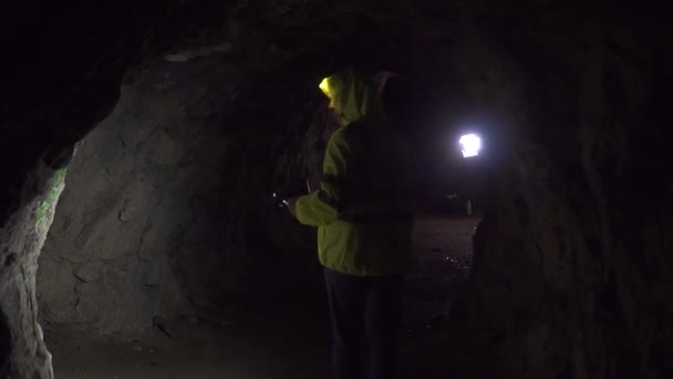 손전등과 자원 봉사 남자는 어두운 동굴, 느린 모에에서 남자를 찾으십시오 — 비디오