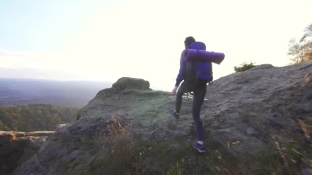 Viaggiatore donna con uno zaino con le braccia alzate sulla cima di una montagna, concetto dei vincitori vista posteriore — Video Stock