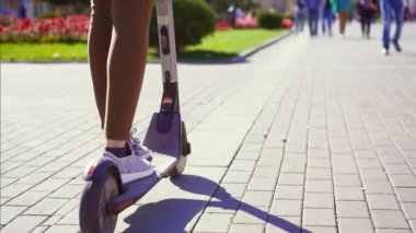 Kız hamle şehirde bir elektrikli scooter üzerinde Kapat