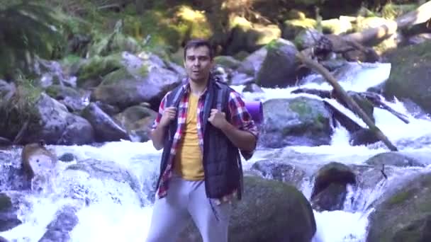 Προσωπογραφία άνδρα τουρίστας στο δάσος ενάντια σε ένα ποτάμι βουνό — Αρχείο Βίντεο