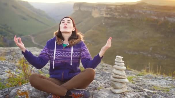 Mädchen beim Yoga auf dem Gipfel des Berges bei Sonnenuntergang — Stockvideo