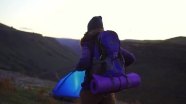 Gün batımında hiking sırt çantası kadınla çadır için döndürülen