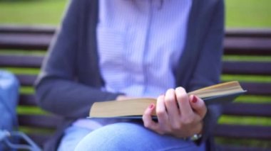 bir kız parkta bir kitap okuma portresi