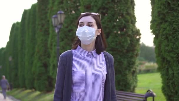 Meisje in een medische masker op haar gezicht is in het park, langzame mo — Stockvideo