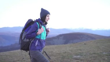 Kadın turist ile bir sırt çantası sırtında Dağları arka plan üzerinde olduğunu