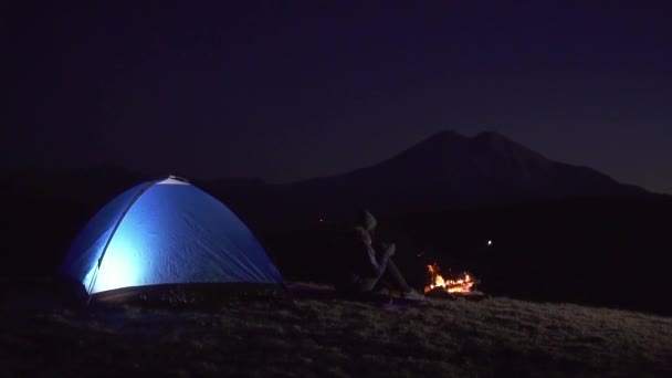 Einsame junge Touristin in der Nacht in den Bergen am Feuer, langsam mo — Stockvideo