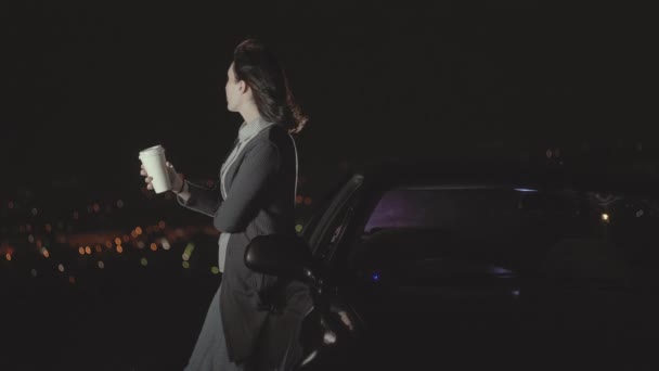 Retrato joven conductor femenino independiente beber café mirando la ciudad de la noche — Vídeos de Stock