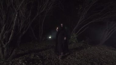 karanlık bir pelerin bir mum ile karanlık bir ormanda mistik kız