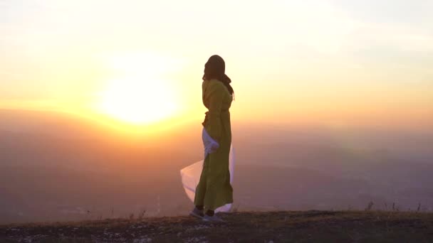 Портрет красивой девушки в хиджабе на закате в горах — стоковое видео