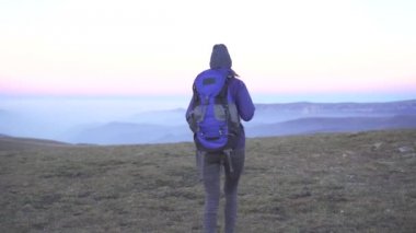 Kadın turist sırtında bir sırt çantası ile dağlar, dikiz arka plan üzerinde olduğunu