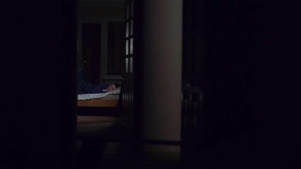 Злодій злочинець у масці розчаровує дівчину подушкою в квартирі — стокове відео