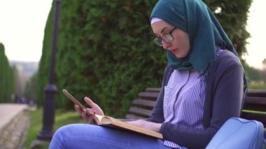 Müslüman öğrenci öğrenme telefon ve ders kitabı yardımı ile nişanlı