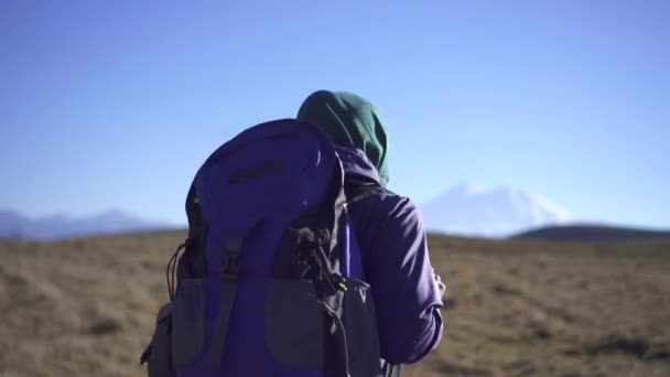 美丽的穆斯林妇女旅行者与背包和眼镜看着相机和去山 — 图库视频影像