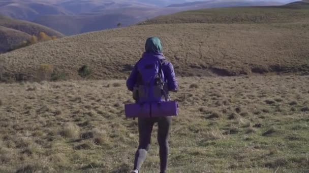 Bella donna musulmana turista con zaino viaggia in belle montagne, vista posteriore — Video Stock