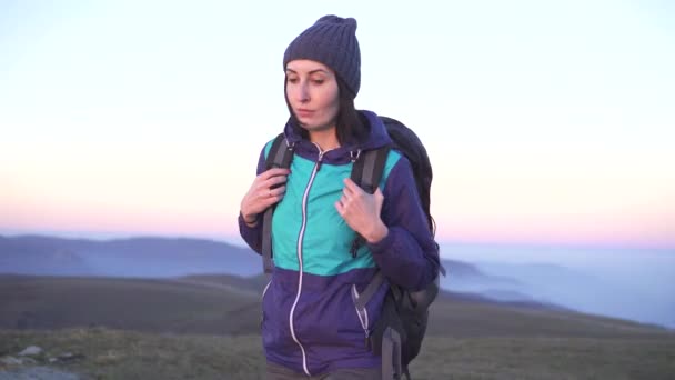 Chica escaladora con una gran mochila en las montañas — Vídeo de stock