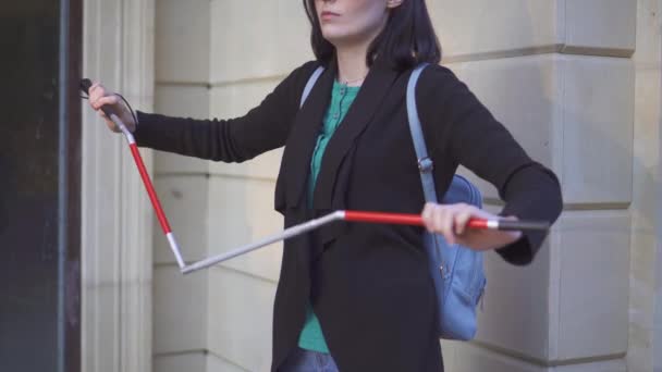 Blind kvinna med glasögon lägger ut en käpp för synskadade — Stockvideo