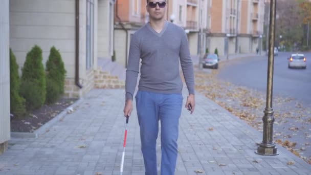 Homme malvoyant dans des lunettes avec une canne dans la ville d'automne — Video