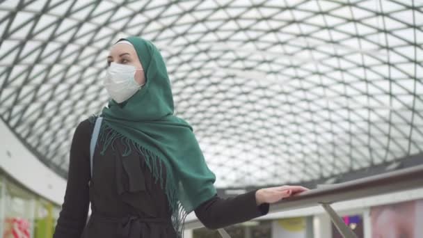 肖像漂亮的穆斯林妇女戴头巾, 她的脸上背着一个背包和一个医疗面具去购物 — 图库视频影像