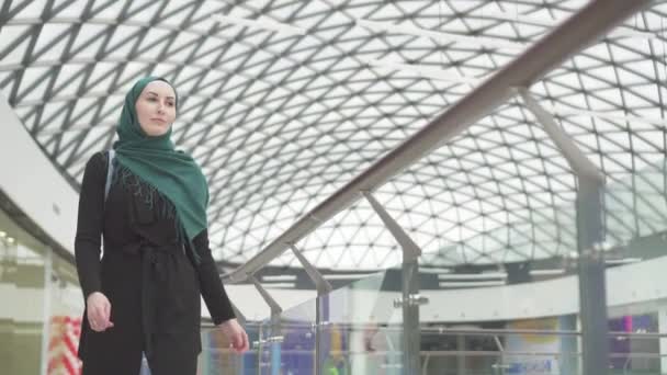 Jolie femme musulmane dans un hijab avec un sac à dos va au magasin, lente mo — Video