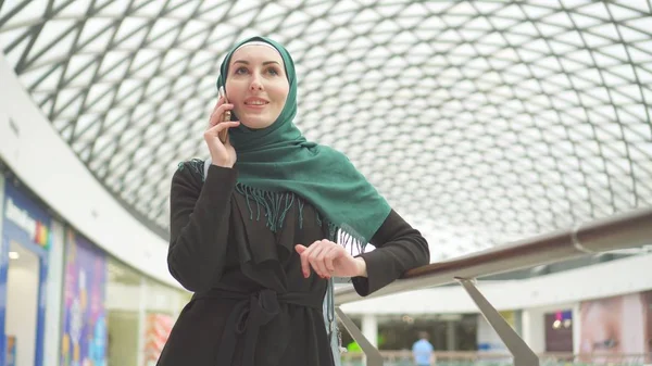 穆斯林女孩在头巾说话的电话在现代商务中心 — 图库照片