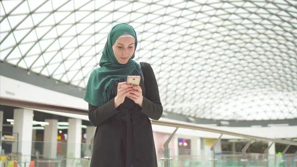 穆斯林女孩在绿色头巾与手机微笑 — 图库照片