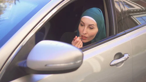 美丽的女孩在头巾画嘴唇在车上 — 图库照片