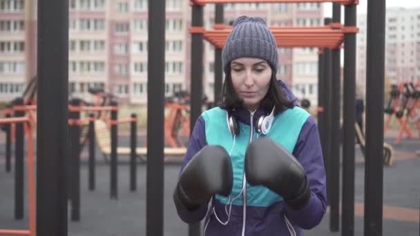 Porträtt av en boxare kvinna i boxning handskar på gatan, långsamma mo — Stockvideo