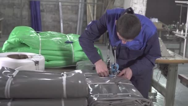 Man warehouse worker is engaged in the packaging of plastic awning — Stock Video