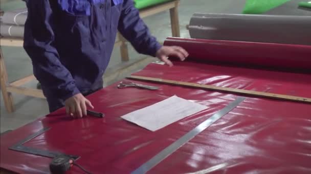 Hombre hace el corte de una carpa de toldo de plástico — Vídeos de Stock