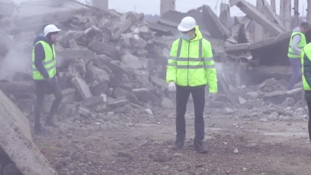 En grupp av räddningsarbetare gå till ruinerna efter jordbävningen — Stockvideo