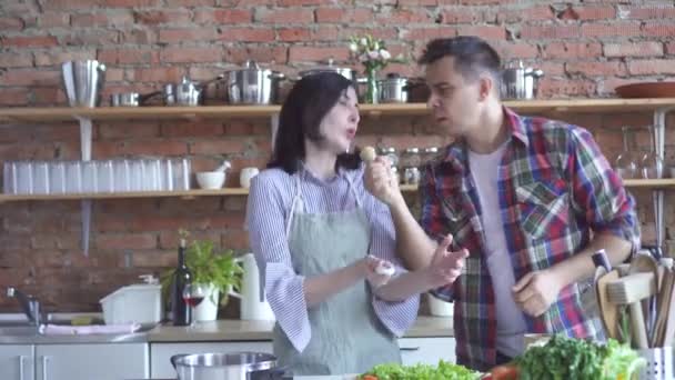 Gelukkige paar man en vrouw koken in de keuken dansen en zingen — Stockvideo