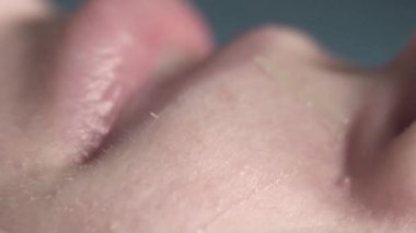 Bir kadın yüzü son derece yakın çekim, acı epilasyon, yapışkan balmumu şeritler