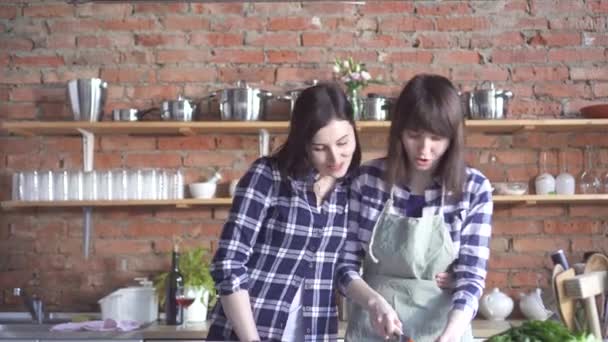 Twee lesbische meisjes in shirtjes in de keuken bereiden — Stockvideo