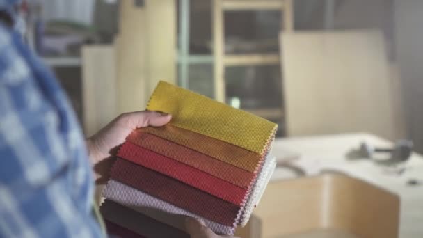 Samples of colored fabric for the manufacture of furniture in the hands of men Kraftman — Stock Video